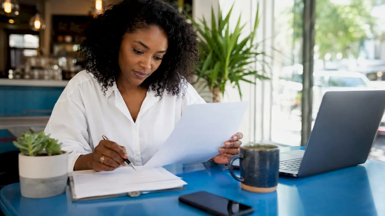 Woman reviewing member onboarding checklist at desk