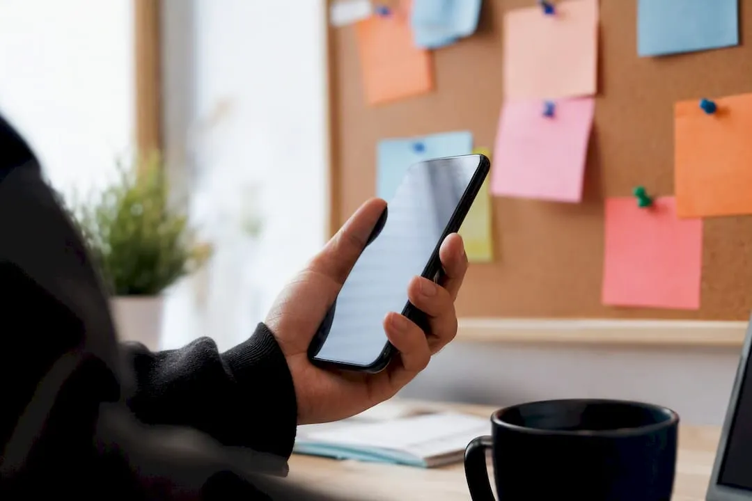 Hand holding smartphone with blurred screen and engagement data