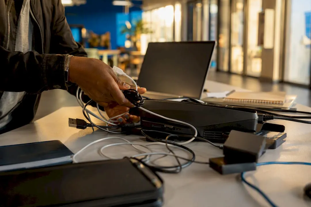 Hands connecting cables in nonprofit workspace