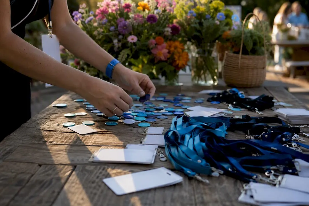 Hands placing event badges and membership tokens