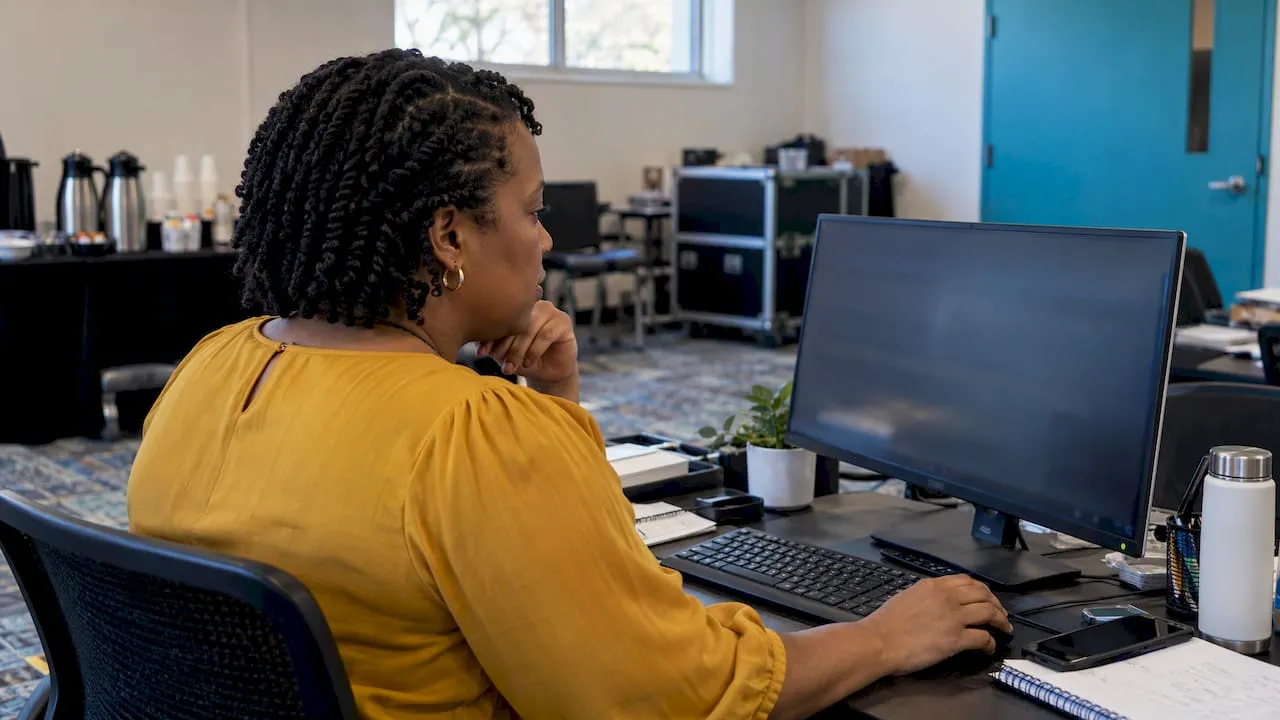 Association director comparing software options at monitor